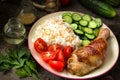 Grilled chicken leg, white rice, slised cucumber with sesame seeds, tomtoes and herbs.