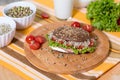 A healthy meal of whole wheat dark brown rye bread, curd cream cheese, radish, alfalfa sprouts, ham, tomatoes, green salad Royalty Free Stock Photo