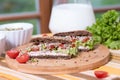 A healthy meal of whole wheat dark brown rye bread, curd cream cheese, radish, alfalfa sprouts, ham, tomatoes, green salad Royalty Free Stock Photo