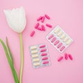 Healthy medical composition with vitamins and white flowers on pink background. Flat lay, top view Royalty Free Stock Photo