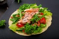 Healthy mexican corn tacos with baked salmon, lettuce, tomato, cucumber