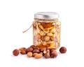 Healthy mix of natural honey with different nuts in a jar on white background