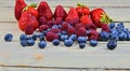 Healthy mixed fruit and ingredients with strawberry, raspberry, blueberry. Berries on rustic white wooden background Royalty Free Stock Photo