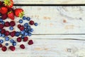 Healthy mixed fruit and ingredients with strawberry, raspberry, blueberry from top view. Berries on rustic white wooden Royalty Free Stock Photo