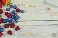 Healthy mixed fruit and ingredients with strawberry, raspberry, blueberry from top view. Berries on rustic white wooden Royalty Free Stock Photo