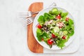 Mixed salad top view on a marble and wood serving board