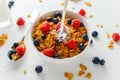 Healthy Morning Breakfast honey Corn flakes with fresh fruits of Raspberry, blueberries and pouring milk in bowl. Royalty Free Stock Photo