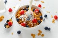 Healthy Morning Breakfast honey Corn flakes with fresh fruits of Raspberry, blueberries and pouring milk in bowl. Royalty Free Stock Photo