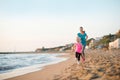 Healthy mother and baby girl running on beach Royalty Free Stock Photo