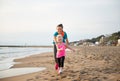 Healthy mother and baby girl running on beach Royalty Free Stock Photo