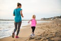 Healthy mother and baby girl running on beach Royalty Free Stock Photo