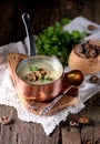 Healthy Mushroom cream soup with celery and parsley on an old wooden background. Rustic style. Royalty Free Stock Photo