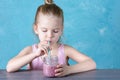 Healthy natural drink, healthy food. The child drinks a berry fruit smoothie through a straw. Royalty Free Stock Photo