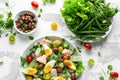 Healthy Nicoise salad with salmon, colourful sweet cherry tomatoes, olives, green beans, cucumber ribbons, soft boiled