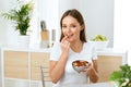 Healthy Nutrition. Beautiful Young Woman Eating Nuts Royalty Free Stock Photo