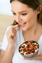 Healthy Nutrition. Beautiful Young Woman Eating Nuts Royalty Free Stock Photo