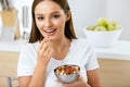 Healthy Nutrition. Beautiful Young Woman Eating Nuts Royalty Free Stock Photo
