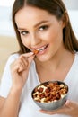 Healthy Nutrition. Beautiful Young Woman Eating Nuts Royalty Free Stock Photo