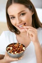 Healthy Nutrition. Beautiful Young Woman Eating Nuts Royalty Free Stock Photo