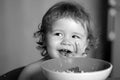 Healthy nutrition for kids. Funny baby eating food himself with a spoon on kitchen. Royalty Free Stock Photo