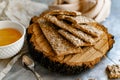 Healthy and nutritious diet bread with sesame and sunflower seeds on a thin crunchy malt base. Near natural bee honey and a wooden