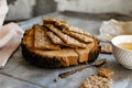 Healthy and nutritious diet bread with sesame and sunflower seeds on a thin crunchy malt base. Near natural bee honey and a wooden