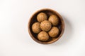 Healthy and nutritious Til Laddu- sesame seed dessert served in a wooden bowl.