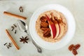 Healthy oatmeal with red pear, pecans and cinnamon, overhead scene