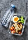 Healthy office lunch box - boiled egg, avocado, tuna spinach cheese sandwiches, tomatoes, bottle of pure water on a gray Royalty Free Stock Photo