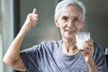 Healthy old elderly grandmother thumbs up for delicious fresh milk drink during breakfast,happy smiling asian senior woman