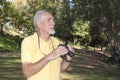 Healthy old man using binoculars to birdwatch Royalty Free Stock Photo