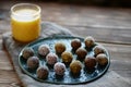 Healthy organic homemade energy balls with nuts, sesame, chia seed and dried fruits on the ceramic plates