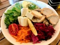 Healthy Organic Salad with Chicken Slices, Avocado, Goat Cheese, Arugula Leaves and Quinoa Served with Olive Oil and Vinegar