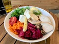 Healthy Organic Salad with Chicken Slices, Avocado, Goat Cheese, Arugula Leaves and Quinoa Served with Olive Oil and Vinegar