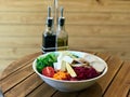 Healthy Organic Salad with Chicken Slices, Avocado, Goat Cheese, Arugula Leaves and Quinoa Served with Olive Oil and Vinegar