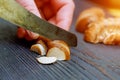 Cut fresh champignons in a standing on black wooden table cutting board, knife with mushroom slices near healthy organic Royalty Free Stock Photo