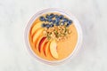 Peach smoothie bowl with blueberries and granola, top view on a marble background Royalty Free Stock Photo