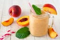Healthy peach smoothie in a mason jar glass, close up against a white wood background Royalty Free Stock Photo