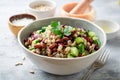 Healthy pearl barley salad with beans, cucumbers, red onion, sunflower seeds, pomegranate and parsley in bowl