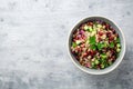 Healthy pearl barley salad with beans, cucumbers, red onion, sunflower seeds, pomegranate and parsley in bowl