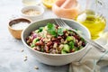 Healthy pearl barley salad with beans, cucumbers, red onion, sunflower seeds, pomegranate and parsley in bowl