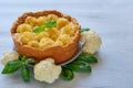 Healthy pie with cauliflower on the gray plate decorated with fresh basil leaves. Vegetarian cauliflower tart on the gray table