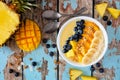 Pineapple, mango smoothie bowl with coconut, bananas, blueberries and granola, top view table scene on wood Royalty Free Stock Photo