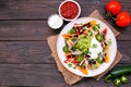 Healthy, plant based bell pepper nachos. Overhead view table scene on a dark wood background. Royalty Free Stock Photo