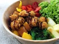 Healthy poke bowl dish with meatballs, vegetables, cabbage, pineapple, seaweed and rice in craft paper packaging. Fitness meal