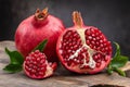 Healthy pomegranate fruit with leaves and half of ripe pomegranate on a cutting board