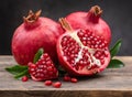 Healthy pomegranate fruit with leaves and open pomegranate on an old wooden board