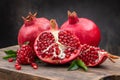 Healthy pomegranate fruit with leaves and open pomegranate on an old wooden board, side view