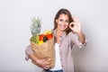 Healthy positive happy woman holding a paper shopping bag full of fruit and vegetables. Young woman holding grocery shopping bag Royalty Free Stock Photo