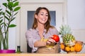 Healthy positive happy woman holding a paper shopping bag full of fruit and vegetables. Young woman holding grocery shopping bag Royalty Free Stock Photo